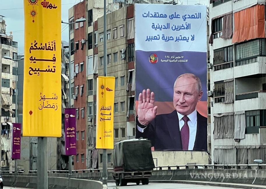 $!Una camioneta frente a un cartel publicitario de las próximas elecciones presidenciales rusas con una imagen de Vladimir Putin, en Beirut, Líbano.