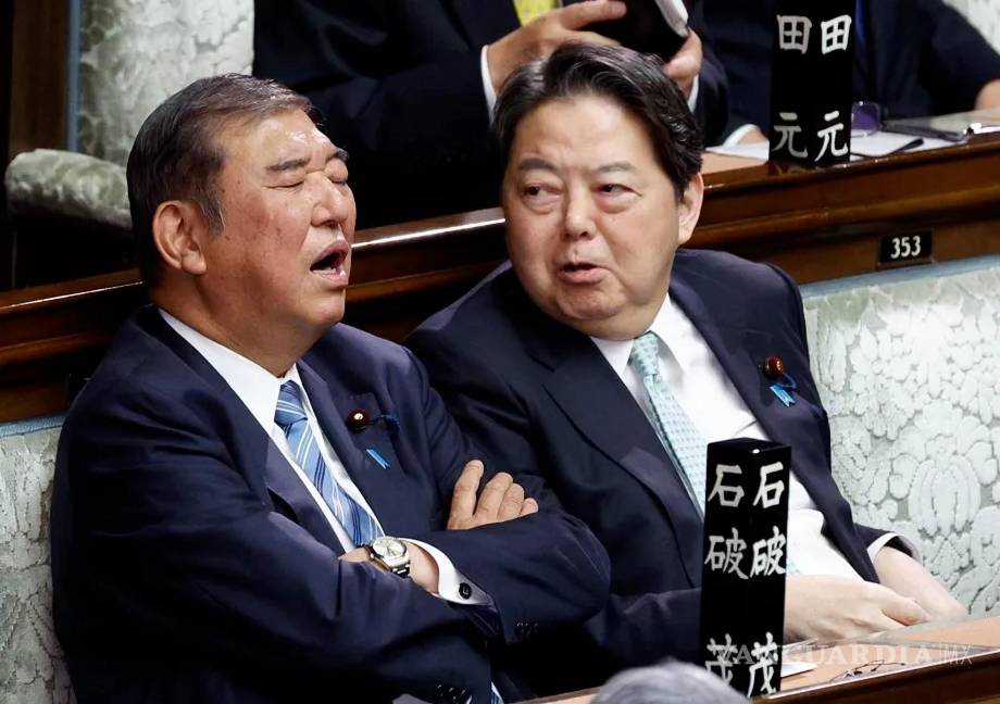 $!El primer ministro japonés aparentemente dormido es observado por el secretario Jefe del Gabinete, en el Parlamento nipón.