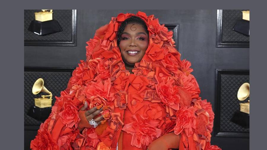 Lizzo llegó a la Alfombra Roja con un atuendo de una naranja vibrante, que la cubrió de pies a cabeza, dejando solo al descubierto su rostro y sus manos.