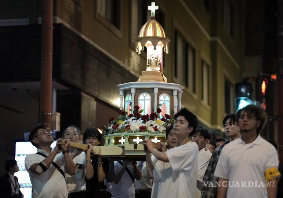 $!La gente lleva una plataforma con una estatua de la Virgen María que fue expuesta al bombardeo atómico, durante una procesión en Nagasaki.