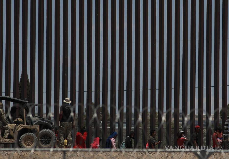 $!Policías de la Guardia Nacional de Texas dialogan por medio de altavoces con migrantes en el muro que divide a México con Estados Unidos, en Ciudad Juárez.