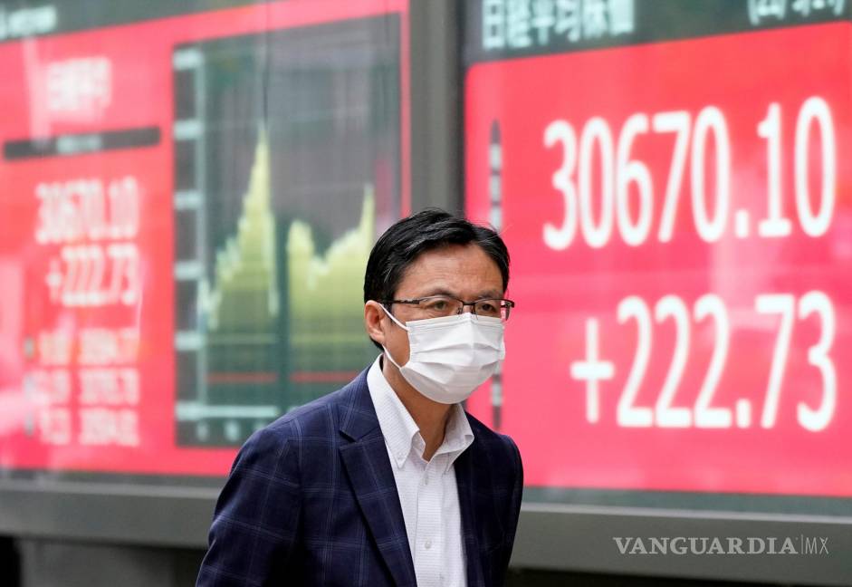 $!Un transeúnte pasa por un tablero indicador del mercado de valores en Tokio, Japón. EFE/EPA/Franck Robichon