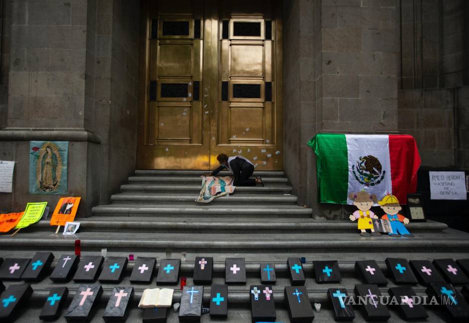 $!Activista contra el aborto coloca un panel de tela de Nuestra Señora de Guadalupe junto a pequeños ataúdes simulados en la entrada de la Corte Suprema.