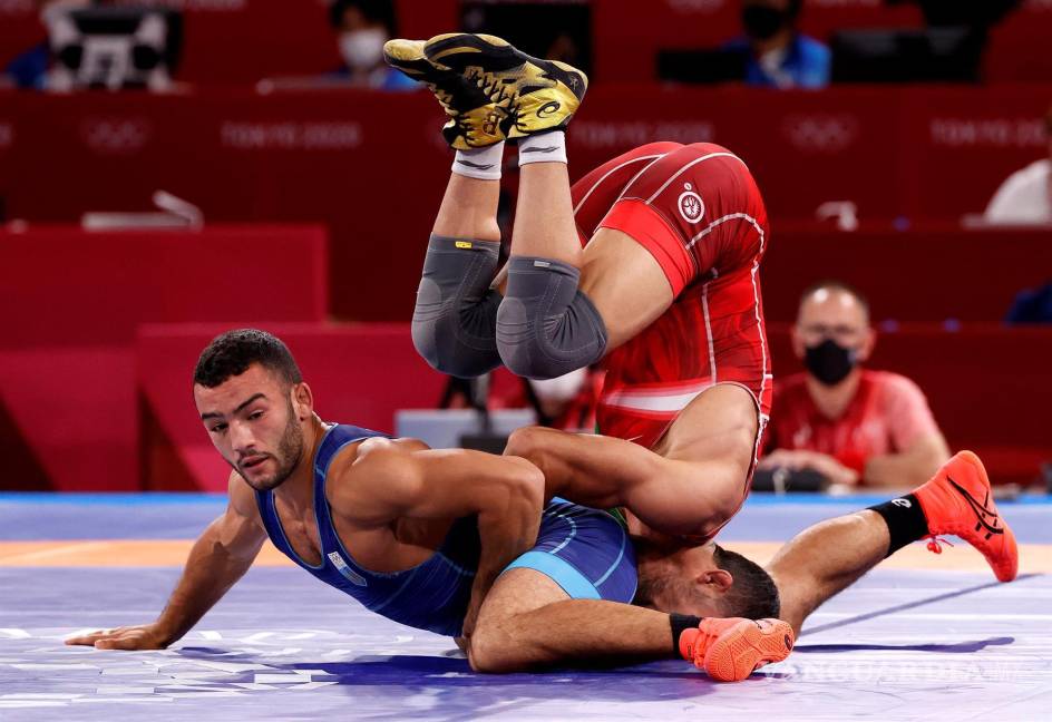 $!Mohammedreza Geraei de Irán (rojo) en acción con Parviz Nasibov de Ucrania (azul) durante el partido final grecorromano masculino de 67 kg en los eventos de lucha libre de los Juegos Olímpicos de Tokio 2020. EFE