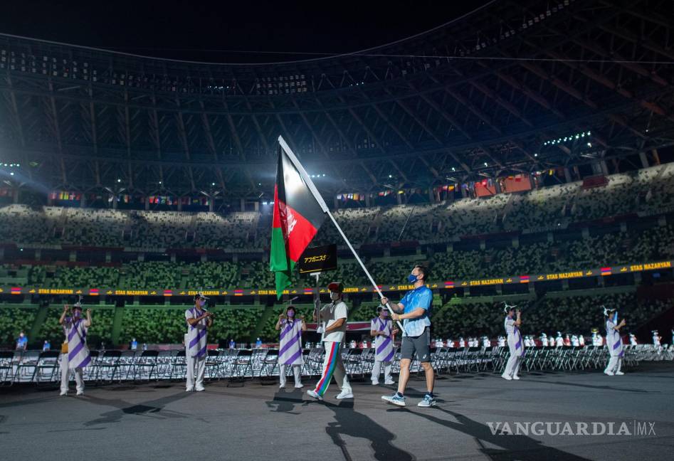 $!Un voluntario paralímpico lleva la bandera nacional de Afganistán durante el desfile de atletas en la ceremonia de apertura de los Juegos Paralímpicos de Tokio 2020, Tokio, Japón. EFE/EPA/Joel Marklund