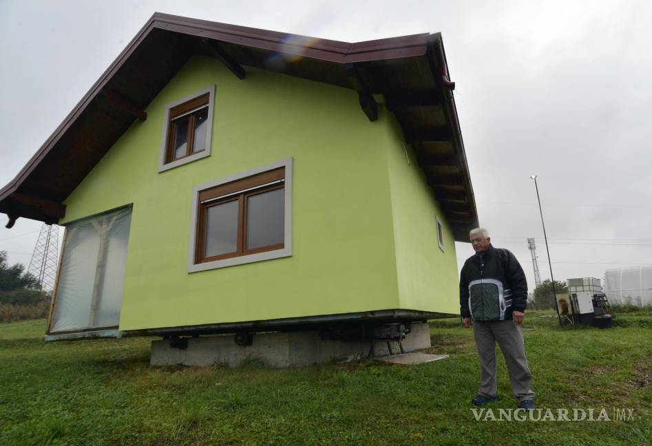 $!Vojin Kusic’s se encuentra frente a su casa giratoria en una ciudad de Srbac, en el norte de Bosnia. La casa diseñada y construida por Vojin Kusic, de 72 años, con su fachada verde y techo de metal rojo, puede rotar un círculo completo para satisfacer los deseos cambiantes de su esposa en cuanto a lo que debería ver cuando mira por las ventanas de su casa. AP/Radivoje Pavicic