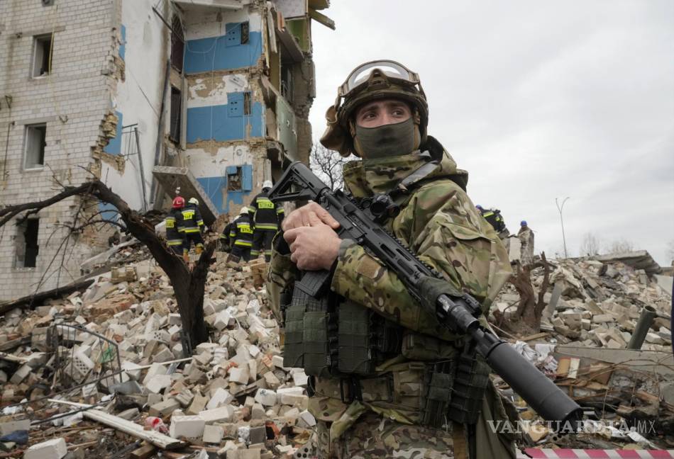 $!Un soldado ucraniano se encuentra en el contexto de una casa de apartamentos arruinada por el bombardeo ruso en Borodyanka, Ucrania.