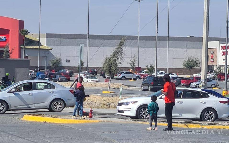 $!La madre observa desde el camellón, mientras su esposo e hijo esperan ayuda en un cruce transitado.