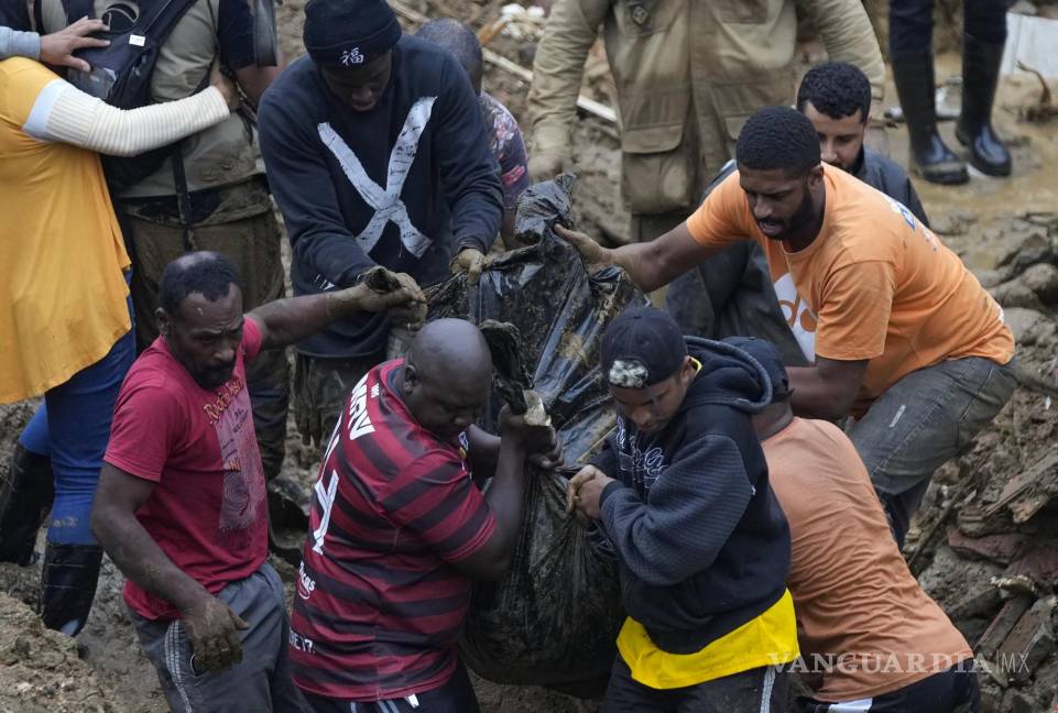 $!Residentes y socorristas recuperan un cadáver en una zona afectada por aludes de tierra en Petrópolis, Brasil. AP/Silvia Izquierdo