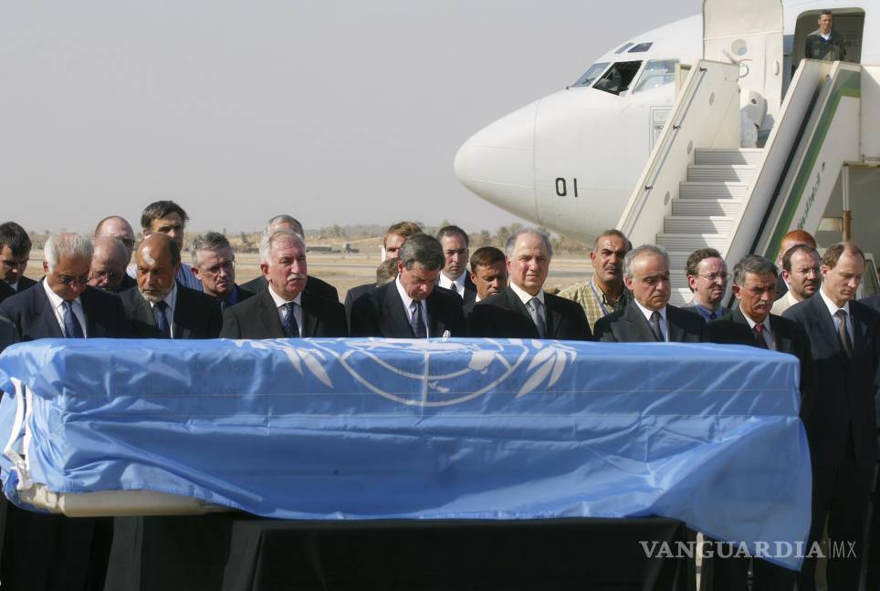 $!El administrador estadounidense en Irak, Paul Bremer, cuarto de izquierda a derecha, junto con funcionarios iraquíes y de la ONU, rinde homenaje ante el féretro de Sergio Vieira de Mello, envuelto en una bandera de la ONU.