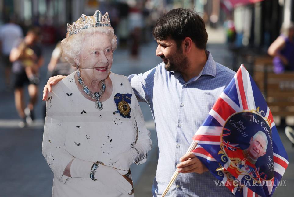 $!Un hombre posa con una figura de tamaño natural de la reina Isabel II en Windsor, Gran Bretaña.