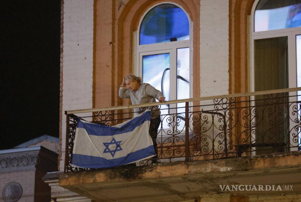 $!Una anciana cuelga una bandera nacional israelí en su balcón en el centro de Kiev, Ucrania.
