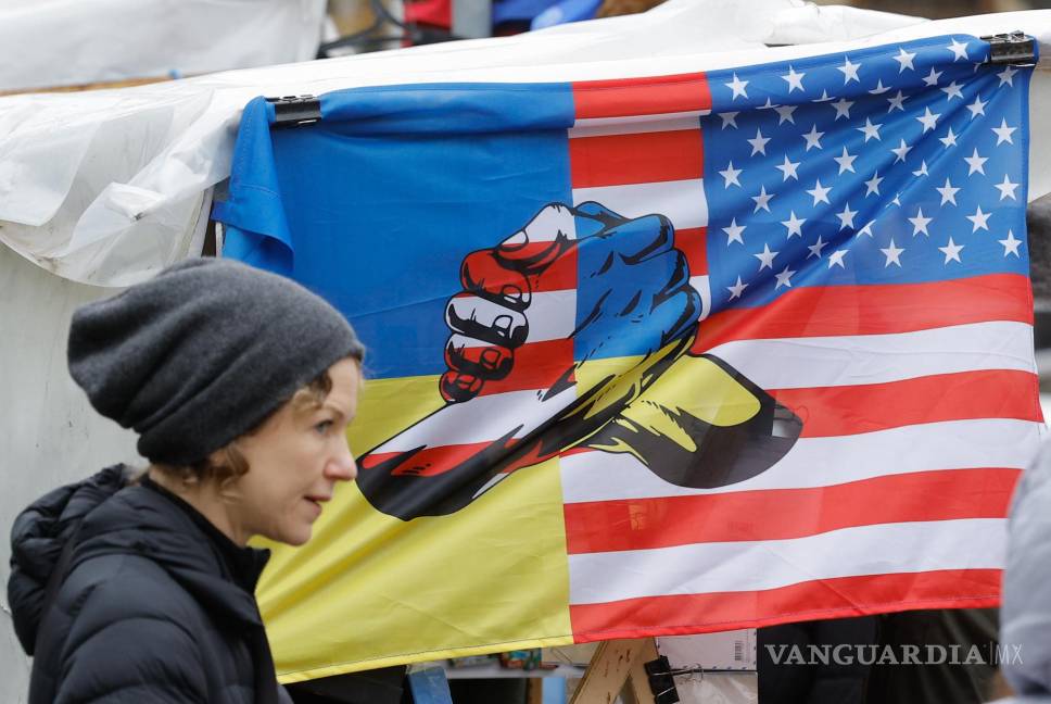 $!Una mujer ucraniana pasa por un puesto de souvenirs con una bandera que representa las banderas de Ucrania y Estados Unidos, en el centro de Kiev, Ucrania.