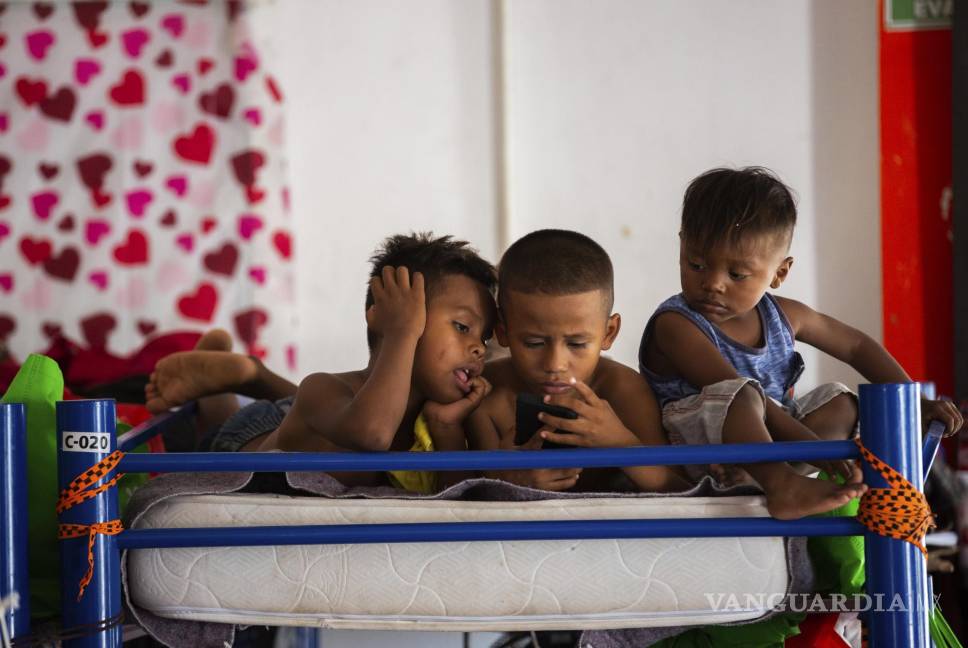 $!Niños migrantes haitianos miran un celular en un refugio en Ciudad Acuña, México. AP/Marie D. De Jesús/Houston Chronicle