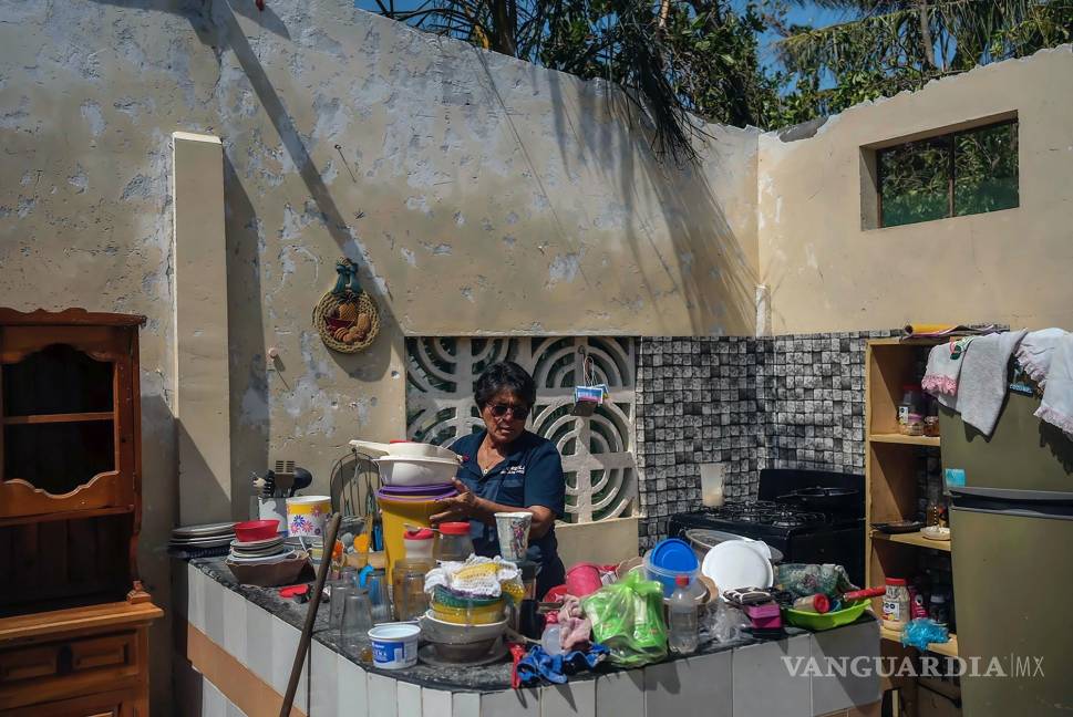 $!Estela Sandoval Díaz acomoda las cosas en su cocina días después de que su vivienda quedó destrozada por el paso del huracán Otis, en Acapulco, México.