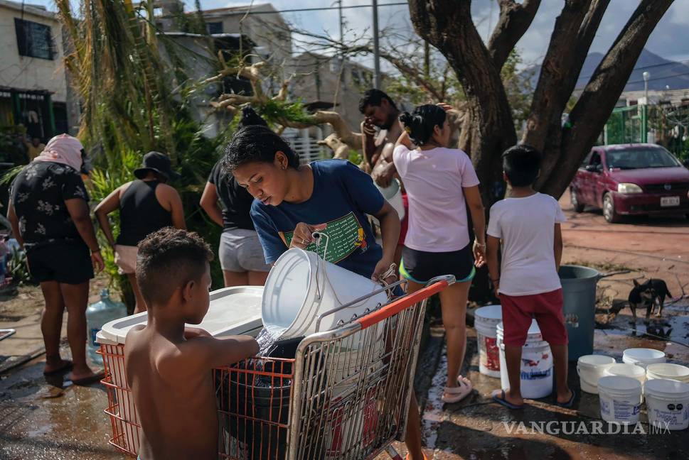 $!Unos hermanos recolectan agua de un pozo público tras el paso del huracán Otis en Acapulco, México.