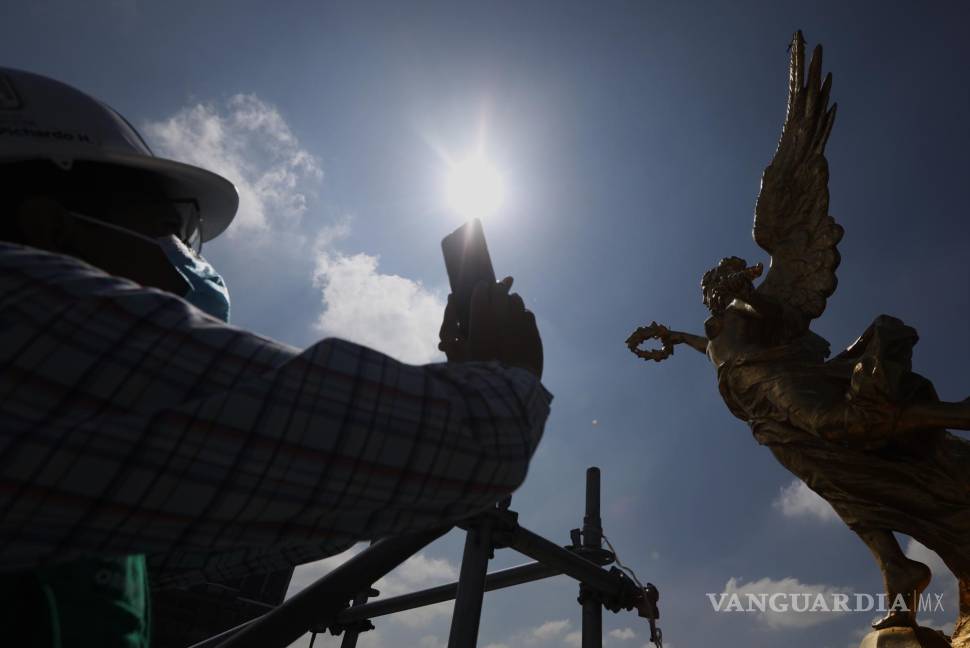 $!Un restaurador toma una foto al Ángel de la Independencia en Ciudad de México (México). EFE/Sáshenka Gutiérrez