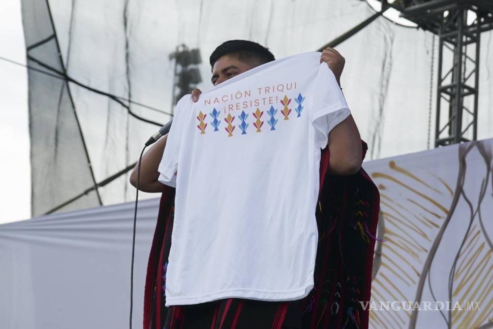 $!El rapero mexicano-triqui Carlos CGH sostiene una camiseta que dice Nación triqui ¡resiste! durante una celebración de los pueblos indígenas en el Zócalo.