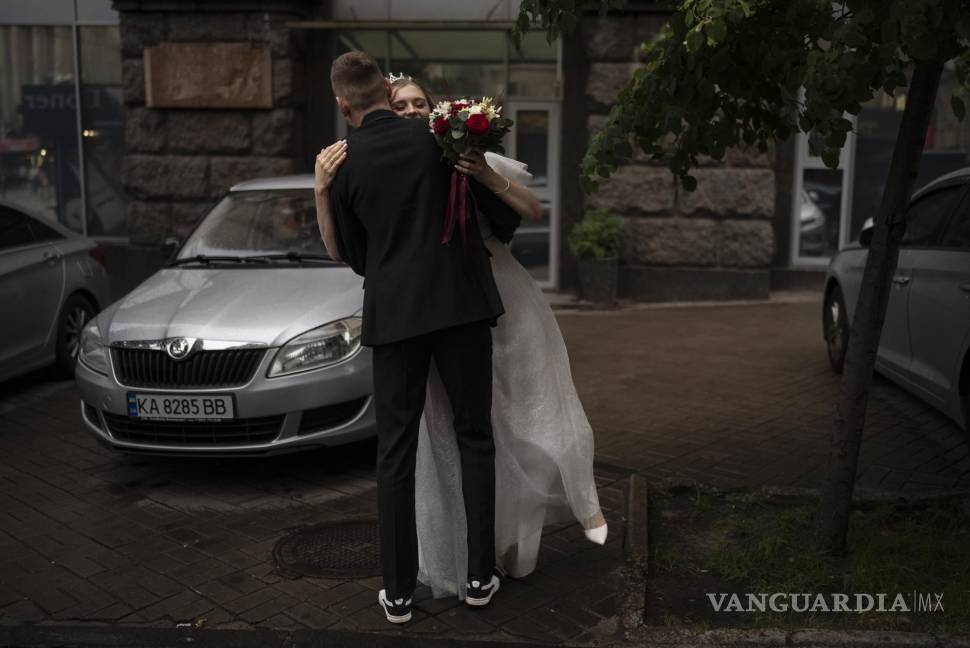 $!Los recién casados, Nikita Timkov, de 25 años, y su novia, Tamika Timkova, de 23, bailanen la calle mientras esperan a su conductor en Kiev, Ucrania.