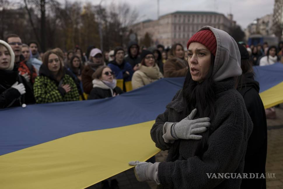 $!Una mujer canta el himno nacional de Ucrania durante una manifestación en el centro de Kiev.