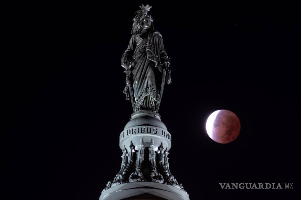 $!Un eclipse lunar parcial que ocurre detrás de ‘La estatua de la libertad’, la estatua de bronce en lo alto del edificio del Capitolio de los Estados Unidos en Washington, DC. EFE/EPA/Michael Reynols