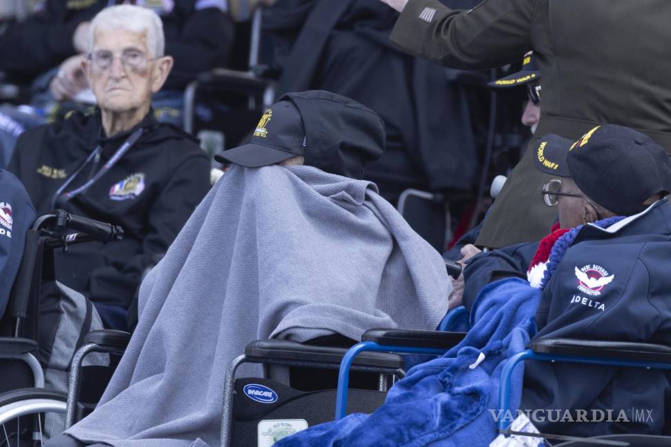 $!Un veterano estadounidense se cubre con una manta mientras espera el inicio de la ceremonia conmemorativa del desembarco del Día D en Normandía