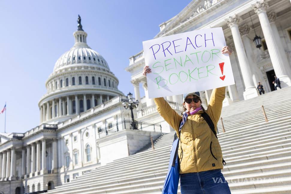 $!Susie Hodges sostiene un cartel en apoyo al senador demócrata Cory Booker, quien dio un discurso maratónico en el Senado contra las políticas de Trump.