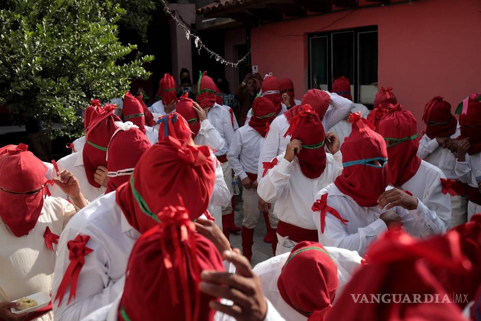 $!Hombres vestidos de soldados romanos con capucha roja, conocidos como “espías”, en el ritual de la aprehensión de Jesús de Nazaret en Tzintzuntzan, Michoacán.
