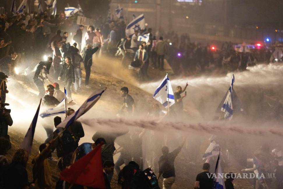 $!Policías israelíes emplean un cañón de agua para dispersar a los manifestantes que cortan una autopista en Tel Aviv, Israel.