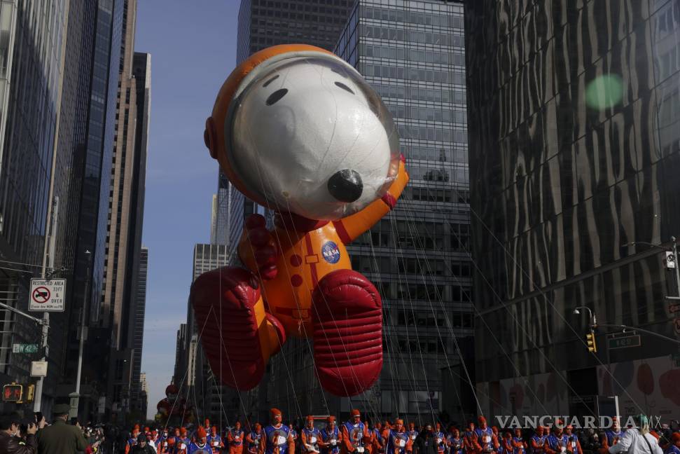 $!El astronauta Snoopy es arrastrado por manipuladores de globos por la Sexta Avenida durante el Desfile del Día de Acción de Gracias de Macy’s en Nueva York. AP/Jeenah Moon