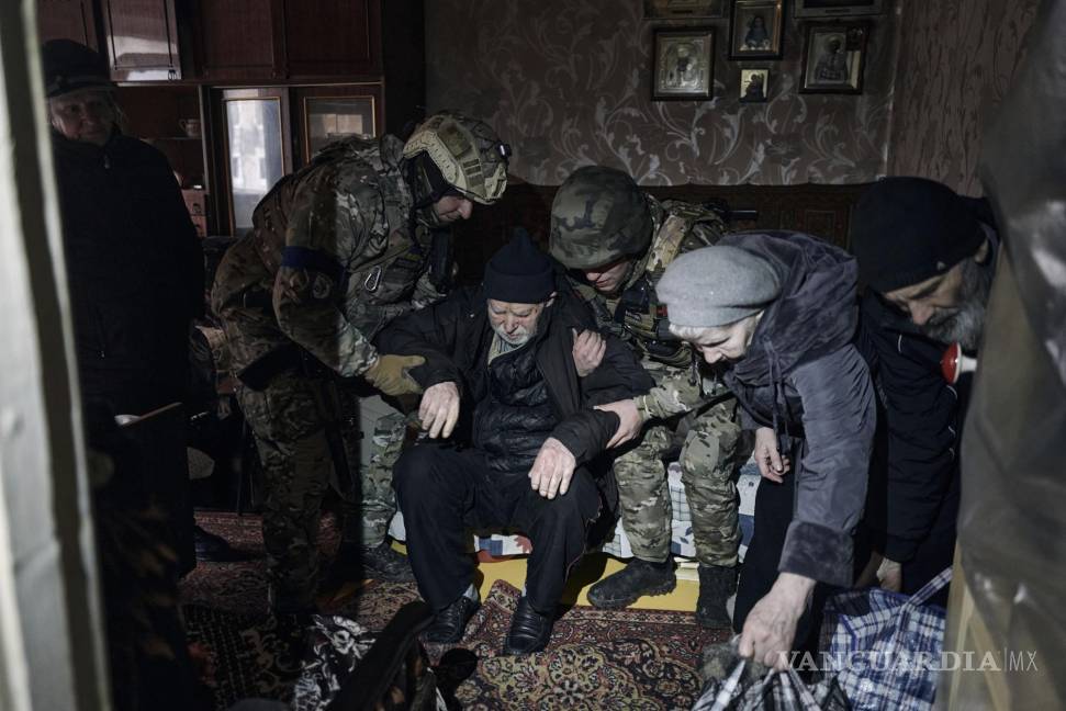 $!Agentes de policía ayudan a un anciano residente discapacitado a entrar en un coche de evacuación en Avdiivka, región de Donetsk, Ucrania.