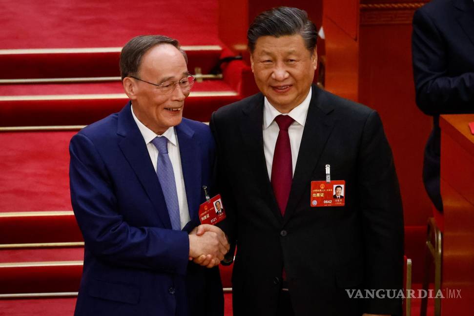 $!El presidente chino, Xi Jinping (d), le da la mano al vicepresidente Wang Qishan (i) durante la Tercera Sesión Plenaria de la Asamblea Popular Nacional en Beijing.