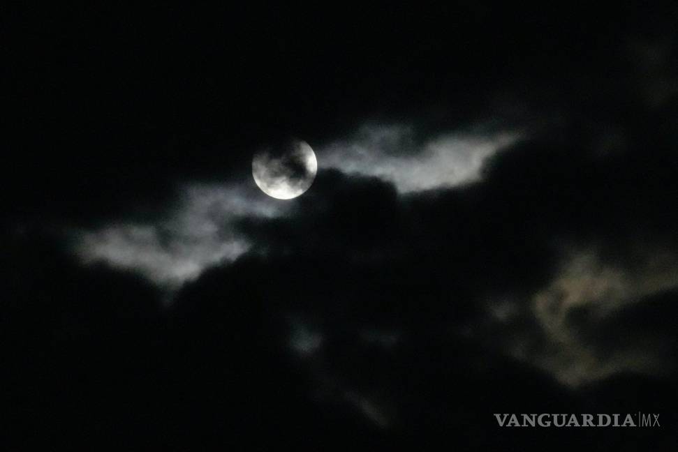 $!La luna llena se puede ver detrás de las nubes en Johannesburgo, Sudáfrica. Durante un fenómeno conocido como la “Luna de Fresa”.