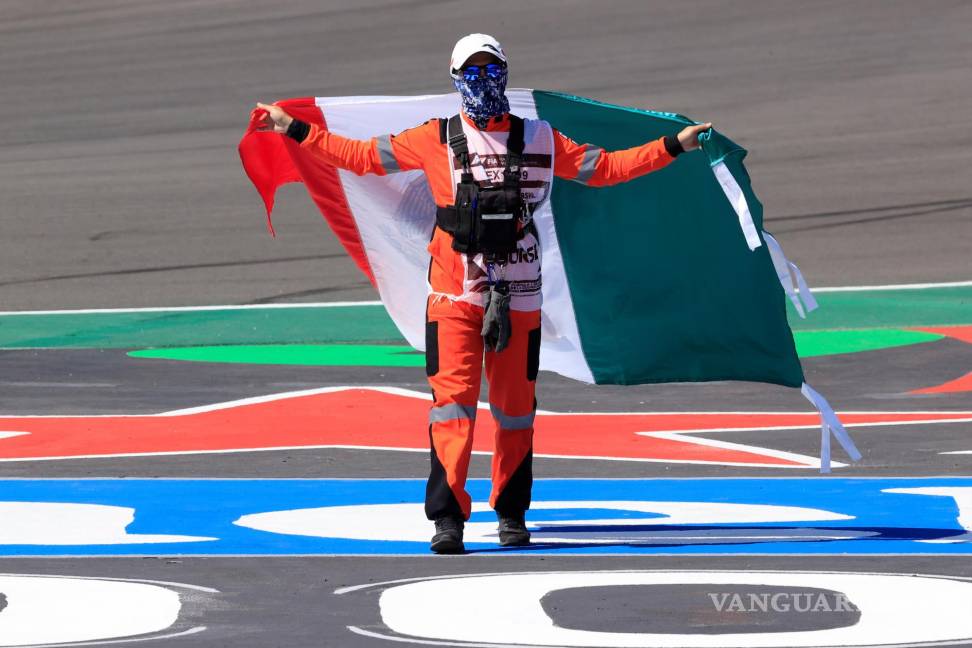$!Un comisario de campo ondea una bandera de México hoy, en el Gran Premio de Fórmula Uno de México que se realiza en el Autódromo Hermanos Rodríguez en Ciudad de México