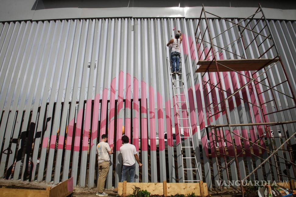 $!Artistas pintan con colores el nuevo muro instalado en la frontera con Estados Unidos para protestar por la renovación de la pared y por la crisis migratoria que se vive en la zona este sábado, en Tijuana.