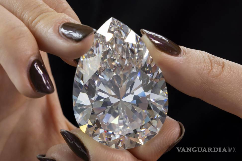 $!Un aempleada de Christie’s sostiene ‘The Rock’, el diamante blanco más grande jamás visto en la historia del mercado de subastas, en Ginebra, Suiza.