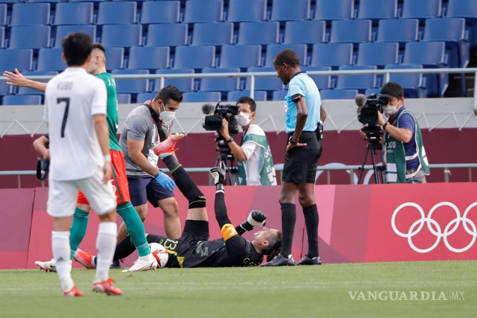 $!El portero mexicano Guillermo “Memo” Ochoa (c) recibe asistencia médica en el encuentro por la medalla de bronce entre las selecciones de México y Japón durante los Juegos Olímpicos 2020. EFE