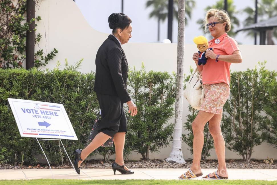 $!Kim Dryer (d) lleva un muñeco hecha a mano del candidato presidencial republicano Donald Trump afuera de un centro de votación en West Palm Beach.