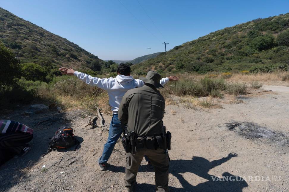 $!Un agente de la Patrulla Fronteriza revisa a un migrante que busca asilo antes de que lo transporten y procesen erca de Dulzura, California.