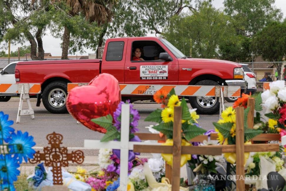$!Un pasajero en una camioneta mira un sitio conmemorativo donde ocho migrantes murieron mientras esperaban en una parada de autobús en Brownsville, Texas.