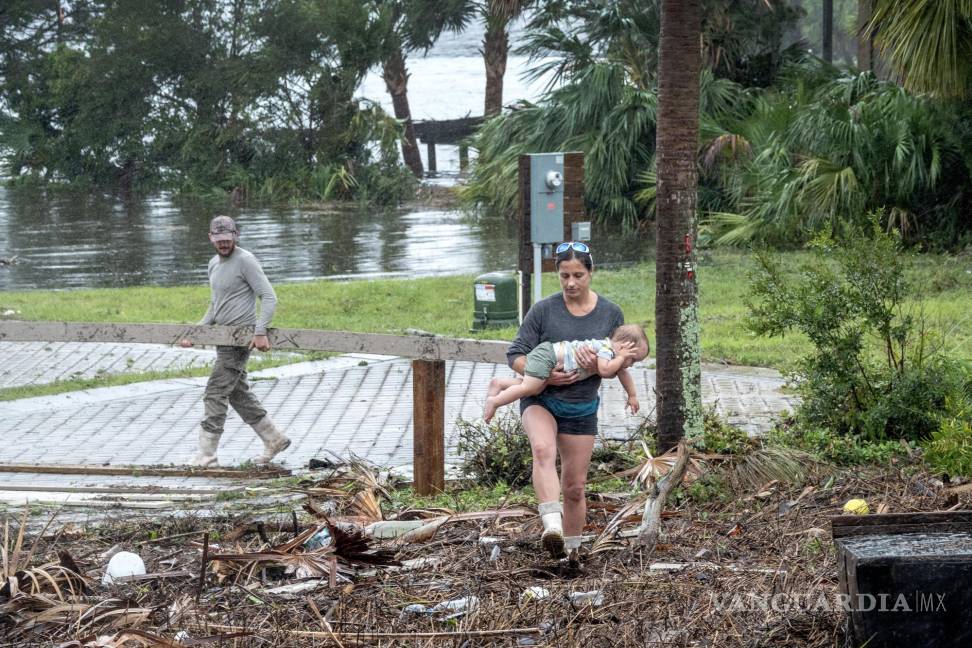 $!Una familia supervisa los destrozos dejados por el huracán, en Jena, cerca de Keaton Beach, Florida.