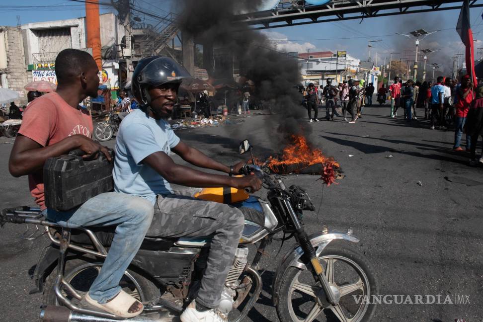 $!Manifestantes protestan para exigir la renuncia del primer ministro Ariel Henry este jueves en Puerto Príncipe, Haití.