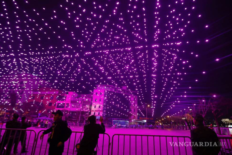 $!Un hombre toma fotografías durante un espectáculo de luces con drones en la víspera del Año Nuevo Lunar en Hanoi, Vietnam.