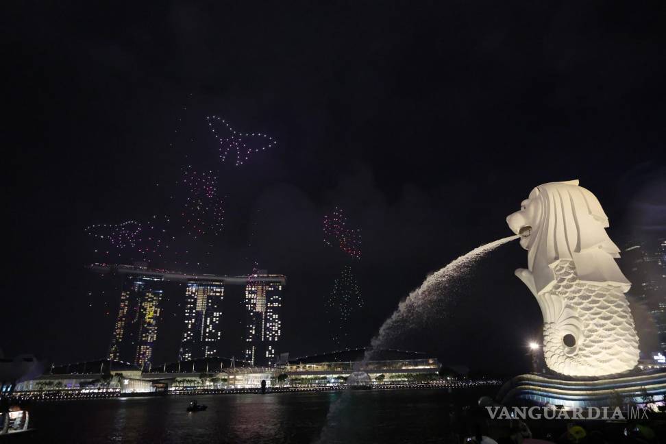 $!Espectáculo con drones en el primer día del Año Nuevo Lunar chino a lo largo del paseo marítimo de Marina Bay con el Merlion en primer plano (R) en Singapur.