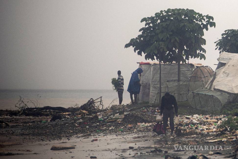 $!Personas caminan por una playa tras el paso del huracán Melissa este jueves, en Petit-Goâve, Haití. Al menos 20 personas murieron y otras diez desaparecieron.