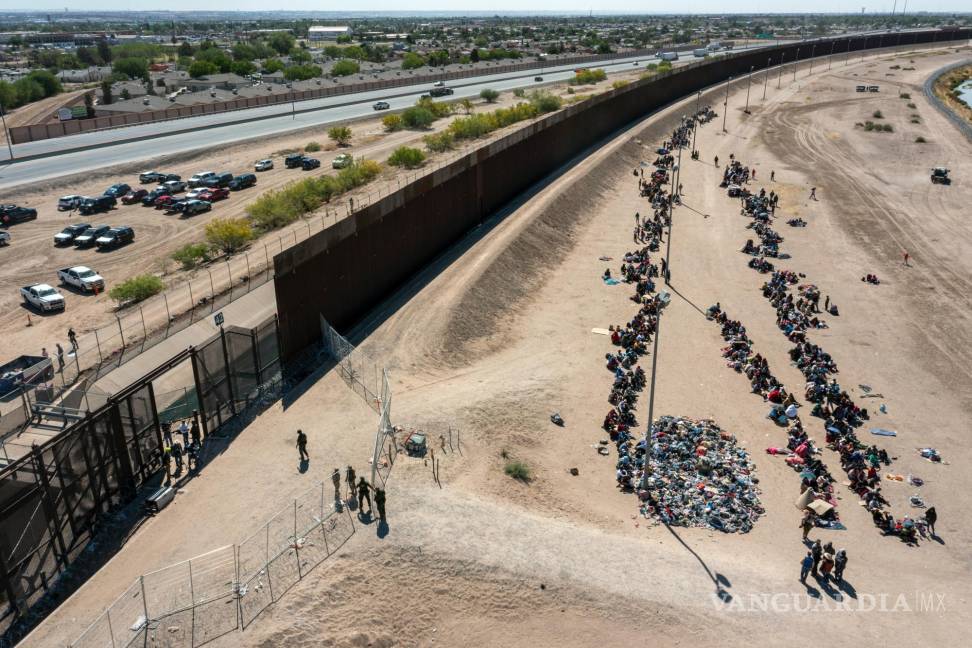 $!Migrantes forman filas afuera de la valla fronteriza para ser trasladados a una instalación de la Patrulla Fronteriza de Estados Unidos en El Paso, Texas.