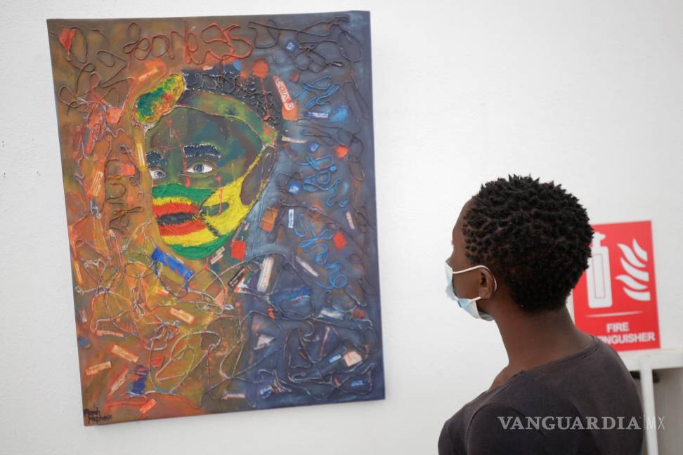 $!Una mujer mira una pintura sobre COVID-19 en la Galería Nacional de Arte en Harare, Zimbabwe. EFE/EPA/Aaron Ufumeli