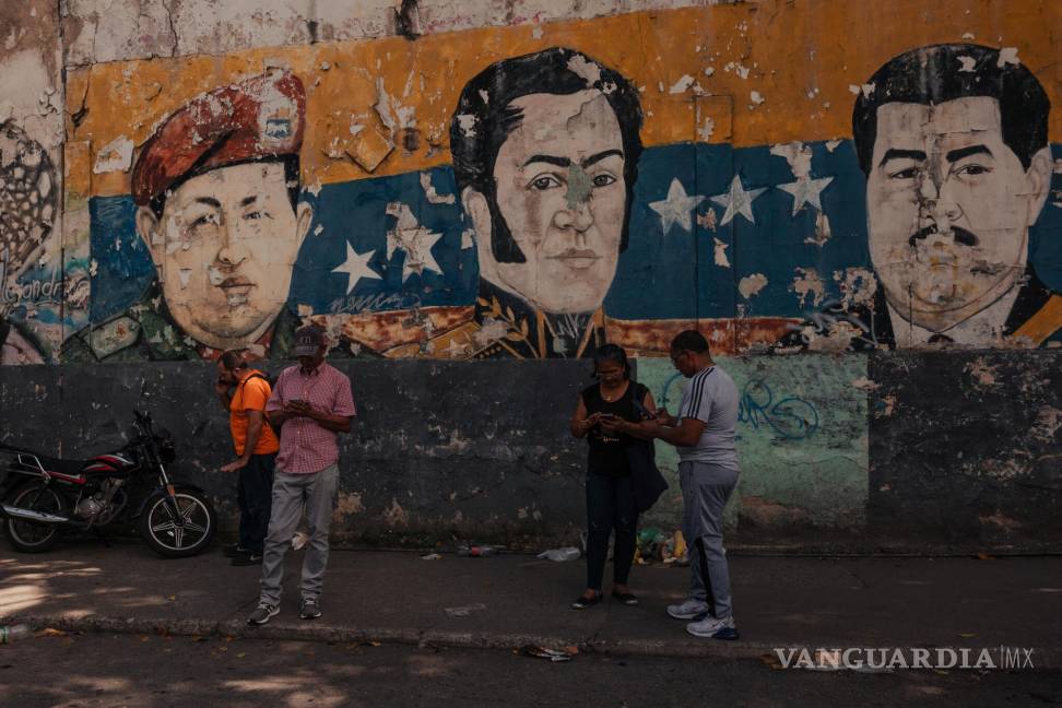 $!Mural de Hugo Chávez, Simón Bolívar y Nicolás Maduro cerca de un centro electoral de votación en las elecciones presidenciales en Petare, Venezuela.