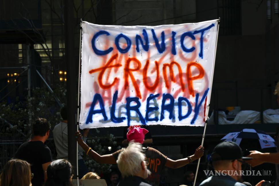 $!Una mujer sostiene una pancarta frente al tribunal penal de Nueva York el primer día del juicio contra Donald Trump en Nueva York.