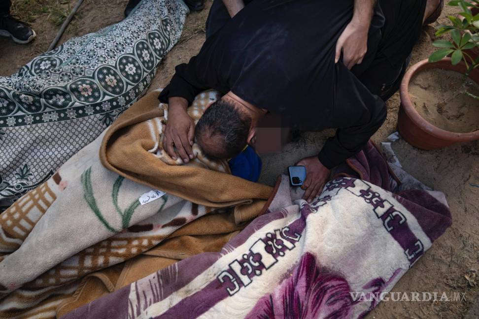 $!Palestinos llorando a parientes muertos en un bombardeo israelí sobre la Franja de Gaza, en una morgue de Khan Younis.